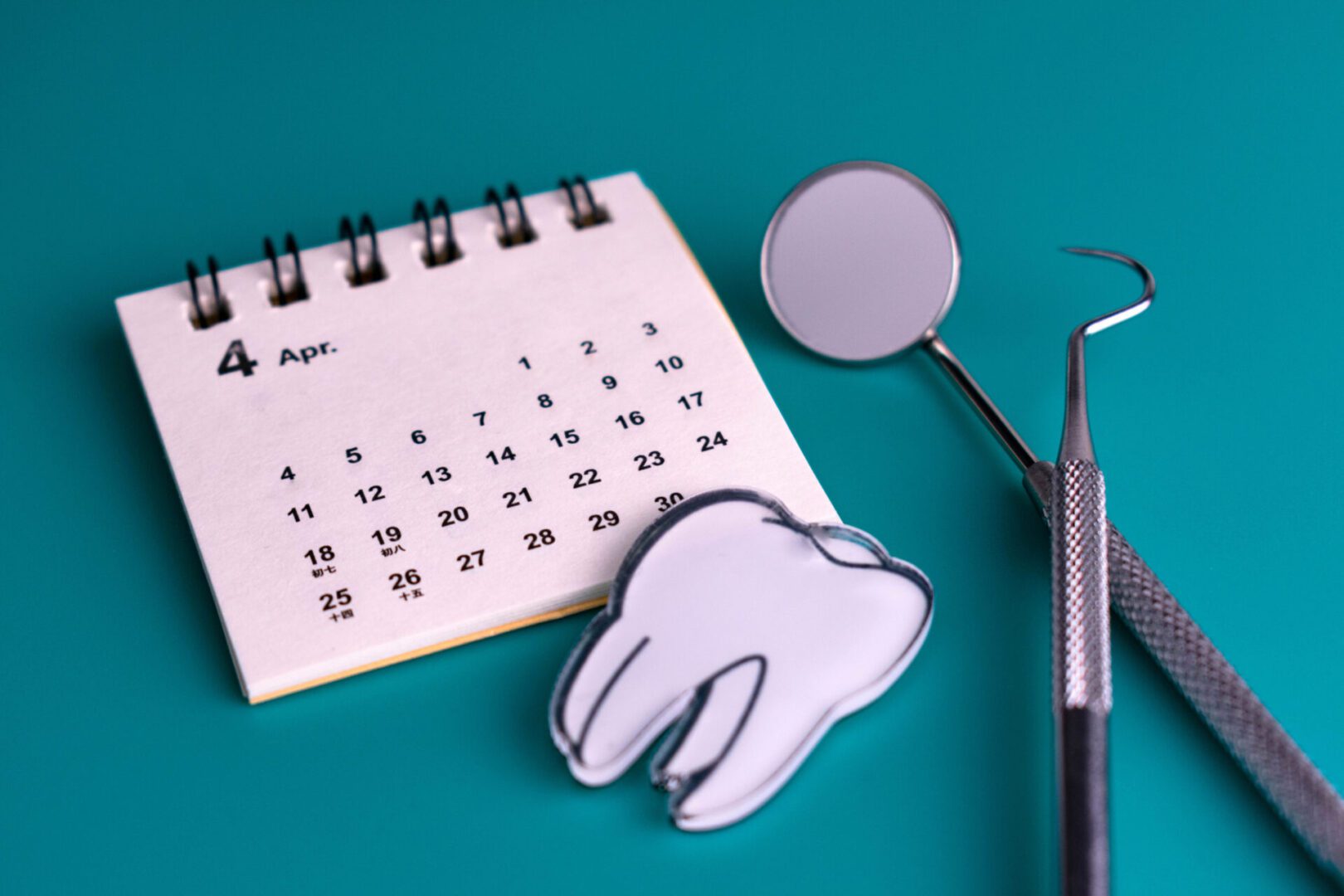 Dental tools with calendar and tooth illustration.