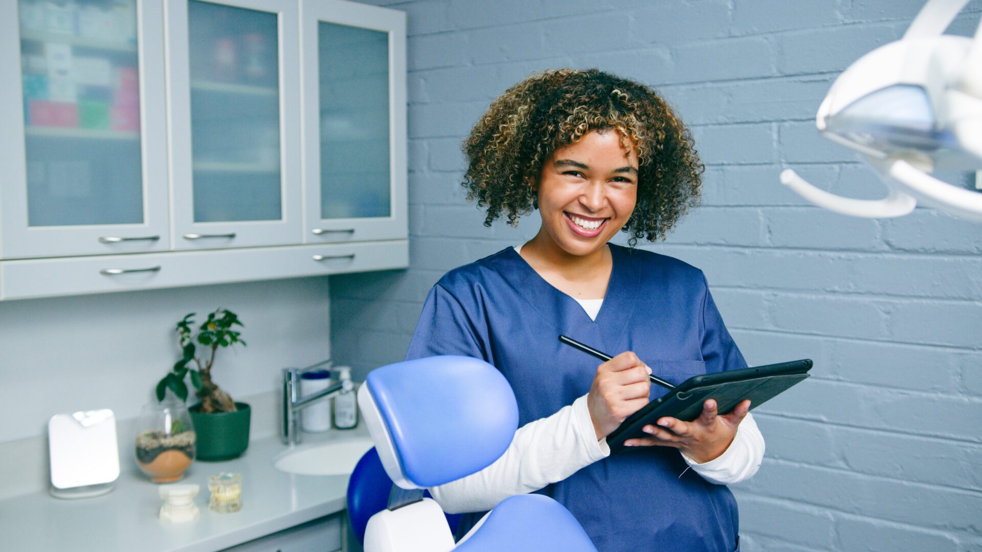 Smiling dentist holding a digital tablet.